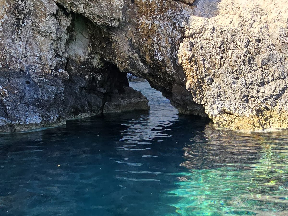 Glasklares, türkises Wasser an einer Grotte